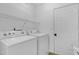Functional laundry room with white appliances, wire shelving, and a door for efficient home management at 512 N Waters Edge Dr, Durham, NC 27703
