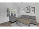 Comfortable living room with a gray sofa, armchair, wood floors, and stylish herringbone coffee table at 512 N Waters Edge Dr, Durham, NC 27703