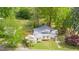 Aerial view of a charming home with lush landscaping, mature trees, and metal roof at 516 W Fourth St, Siler City, NC 27344