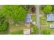 Overhead view of a home with a metal roof surrounded by lush greenery and mature trees at 516 W Fourth St, Siler City, NC 27344