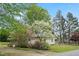 A cozy single-story home surrounded by lush landscaping and mature trees in a serene setting at 516 W Fourth St, Siler City, NC 27344