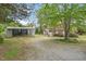 View of a charming single-story home featuring a detached garage and gravel driveway at 516 W Fourth St, Siler City, NC 27344