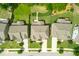 Aerial view of homes with well-maintained yards and driveways on a tree-lined street at 521 Wildwood Farm Way, Holly Springs, NC 27540