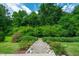 A tranquil backyard with a stone pathway leading through manicured landscaping and lush greenery at 521 Wildwood Farm Way, Holly Springs, NC 27540