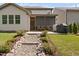 Landscaped backyard leading to screened porch with stone accents and modern outdoor grill at 521 Wildwood Farm Way, Holly Springs, NC 27540