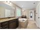 Bathroom featuring double vanity with granite countertops, soaking tub, and tile flooring at 521 Wildwood Farm Way, Holly Springs, NC 27540