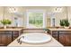 Beautiful bathroom featuring a soaking tub with dual vanities and large mirrors at 521 Wildwood Farm Way, Holly Springs, NC 27540