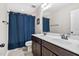 Bathroom with double vanity, large mirror, and shower with blue curtain at 521 Wildwood Farm Way, Holly Springs, NC 27540