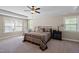 Bright bedroom with large windows, tray ceiling, ceiling fan, and coordinated bedding and furniture at 521 Wildwood Farm Way, Holly Springs, NC 27540