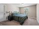 Comfortable bedroom with carpet, large window, and side table with lamp at 521 Wildwood Farm Way, Holly Springs, NC 27540