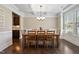 Dining room featuring a large wooden table and chairs, tray ceilings, and views of an adjacent room at 521 Wildwood Farm Way, Holly Springs, NC 27540