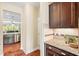 Granite countertops and dark wood cabinets provide beauty and function to this modern, eat-in kitchen at 521 Wildwood Farm Way, Holly Springs, NC 27540