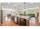 Open-concept kitchen featuring a large island with granite countertops and seating for entertaining guests at 521 Wildwood Farm Way, Holly Springs, NC 27540
