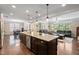 Spacious open-concept kitchen with an island, stainless steel appliances, and an eat-in kitchen area adjacent to the living room at 521 Wildwood Farm Way, Holly Springs, NC 27540