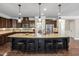 Kitchen featuring a large center island with seating, granite countertops, dark cabinetry, and stainless steel appliances at 521 Wildwood Farm Way, Holly Springs, NC 27540