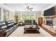 Warm and inviting living room featuring a stone fireplace, comfortable leather furniture, and natural light at 521 Wildwood Farm Way, Holly Springs, NC 27540