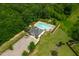 Aerial view of the community pool and clubhouse surrounded by lush trees and well-maintained grounds at 521 Wildwood Farm Way, Holly Springs, NC 27540