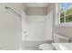 Bright bathroom featuring a white tub/shower combo with window and chrome fixtures at 5505 Armada Dr, Raleigh, NC 27610