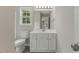 Bathroom featuring a white vanity, commode, mirror and a natural light filled window at 5505 Armada Dr, Raleigh, NC 27610