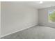 The bedroom has neutral colored walls and carpet, a window and overhead lighting at 5505 Armada Dr, Raleigh, NC 27610