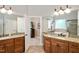 Well-lit bathroom with double vanity featuring granite countertops and framed mirror at 572 W Walker Woods Ln, Clayton, NC 27527