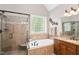 Bathroom featuring a tiled walk-in shower, soaking tub, and vanity with granite countertops at 572 W Walker Woods Ln, Clayton, NC 27527