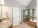Bathroom featuring a vanity with granite counters, soaking tub and glass-enclosed shower at 572 W Walker Woods Ln, Clayton, NC 27527