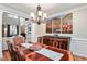 Dining room features a large wooden table, elegant chandelier, and an adjacent living space at 572 W Walker Woods Ln, Clayton, NC 27527