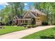 Traditional two-story home with attached garage and driveway surrounded by mature trees and manicured landscaping at 572 W Walker Woods Ln, Clayton, NC 27527