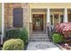 Elegant front door with stone accents, manicured shrubs, and a welcoming entryway at 572 W Walker Woods Ln, Clayton, NC 27527