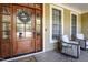 Charming front porch with a decorative wreath, seating, and a stylish glass-paneled front door at 572 W Walker Woods Ln, Clayton, NC 27527