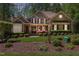 Traditional home featuring beautiful landscaping, a manicured lawn, complemented by dark shutters and a stylish door at 572 W Walker Woods Ln, Clayton, NC 27527