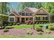 Traditional home featuring beautiful landscaping, a manicured lawn, complemented by dark shutters and a stylish door at 572 W Walker Woods Ln, Clayton, NC 27527