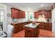 A kitchen features wooden cabinets, granite countertops, and a central island with seating at 572 W Walker Woods Ln, Clayton, NC 27527