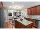 Bright kitchen with island, stainless steel appliances, wooden cabinets, and an open floor plan at 572 W Walker Woods Ln, Clayton, NC 27527
