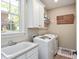 This is a bright laundry room featuring a sink, white cabinets and washer and dryer at 572 W Walker Woods Ln, Clayton, NC 27527