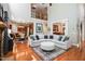 Bright living room with hardwood floors, a large sectional sofa, and open access to the kitchen and dining area at 572 W Walker Woods Ln, Clayton, NC 27527