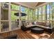 Relaxing screened porch with wood floors, wicker furniture, and views of the wooded backyard at 572 W Walker Woods Ln, Clayton, NC 27527