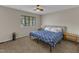 Cozy bedroom with a blue floral bedspread and a window letting in natural light at 5900 Shady Grove Cir, Raleigh, NC 27609
