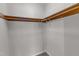 An open, empty closet space with a wooden hanging rack ready for organization and storage at 5900 Shady Grove Cir, Raleigh, NC 27609