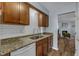 Updated kitchen featuring granite countertops, white backsplash, and stainless steel sink at 5900 Shady Grove Cir, Raleigh, NC 27609