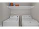 Laundry room with white washer and dryer and shelving above at 5900 Shady Grove Cir, Raleigh, NC 27609