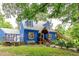 Charming two-story home showcasing a colorful exterior, landscaped yard, and welcoming front porch at 6238 Old 421 Rd, Liberty, NC 27298