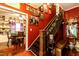 Hallway with wooden staircase adorned with garland, red walls, and hardwood floors at 6238 Old 421 Rd, Liberty, NC 27298