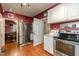 Well-lit kitchen with stainless steel appliances, ample storage, and wood flooring at 6238 Old 421 Rd, Liberty, NC 27298