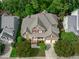 Aerial view of a two-story home with mature trees, a well-manicured lawn, and a spacious driveway at 629 Peach Orchard Pl, Cary, NC 27519