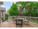 Outdoor wooden deck features a dining set with umbrella, creating an ideal space for outdoor meals at 629 Peach Orchard Pl, Cary, NC 27519