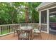 Cozy wooden deck with outdoor dining set and umbrella, surrounded by lush greenery at 629 Peach Orchard Pl, Cary, NC 27519