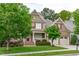 Beautiful home exterior featuring a two-car garage, red shutters, and lush landscaping at 629 Peach Orchard Pl, Cary, NC 27519
