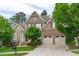 Stunning exterior view of home showcasing a well-kept lawn and two-car garage with shade trees at 629 Peach Orchard Pl, Cary, NC 27519